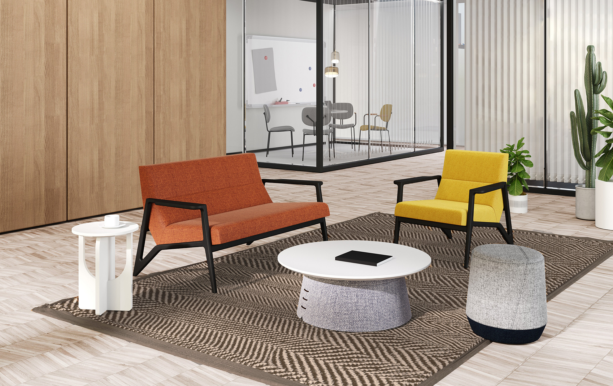 Nowoczesna strefa chillout w biurze: pomarańczowa sofa dwuosobowa i żółty fotel na czarnych stelażach. W tle przeszklona sala konferencyjna, białe stoliki kawowe oraz duży kaktus w donicy.